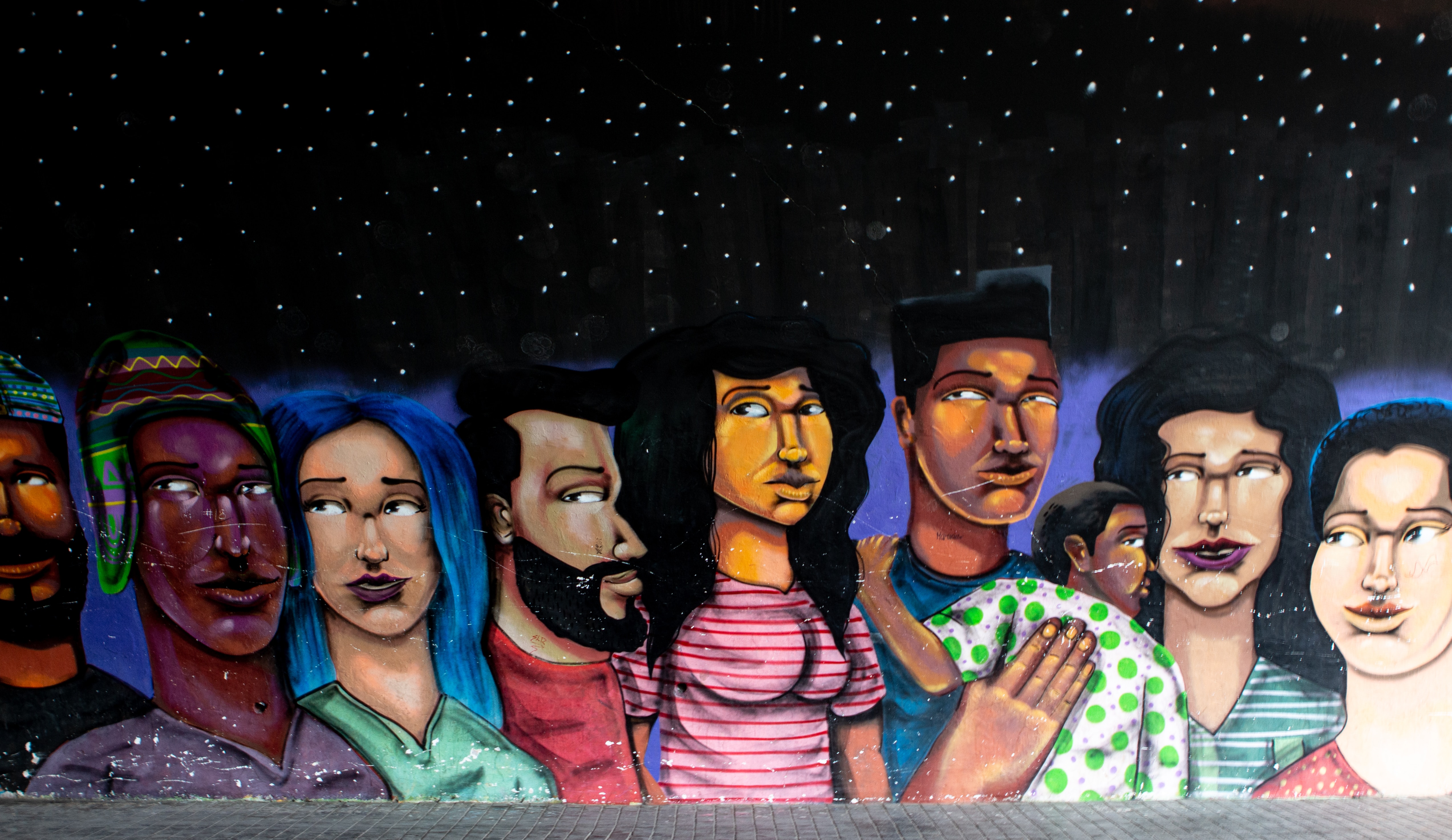 a mural depicting people gathered in a dimly lit room, showcasing unity and diversity