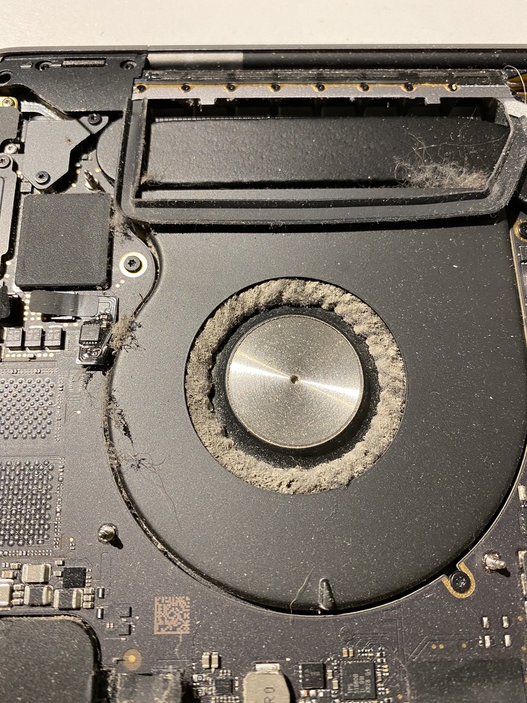left mackbook pro fan clogged up with dust, blocking all of the air flow dividers