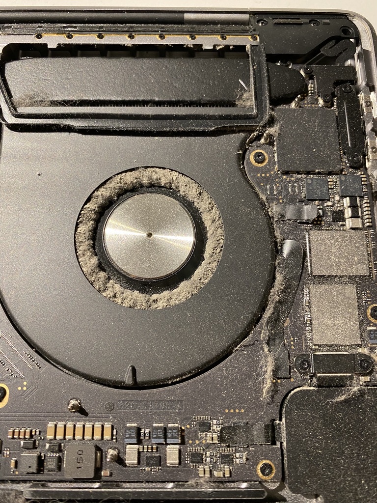 right mackbook pro fan clogged up with dust, blocking all of the air flow dividers
